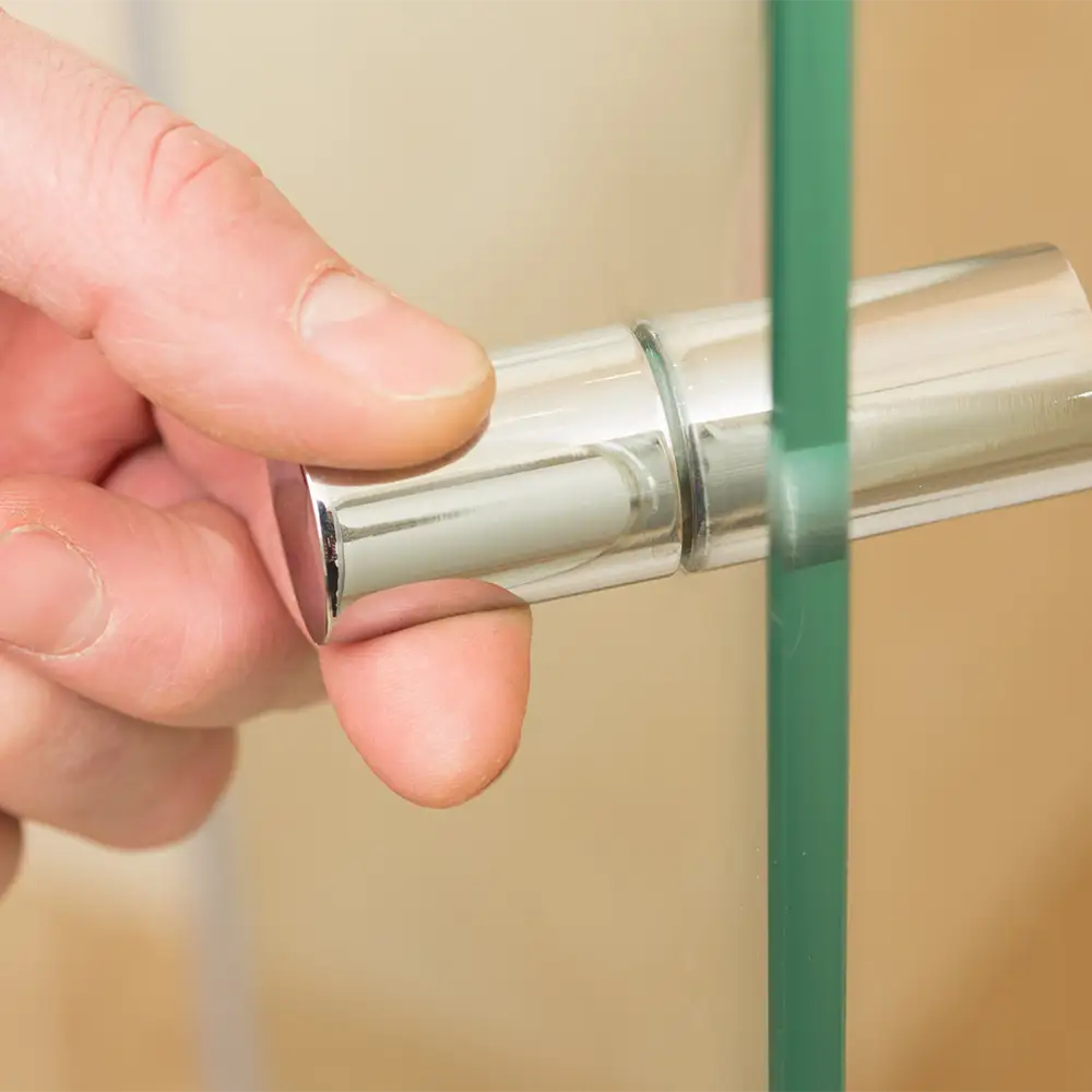 Nahaufnahme eines runden und in Chrom glänzenden Duschtürgriffs